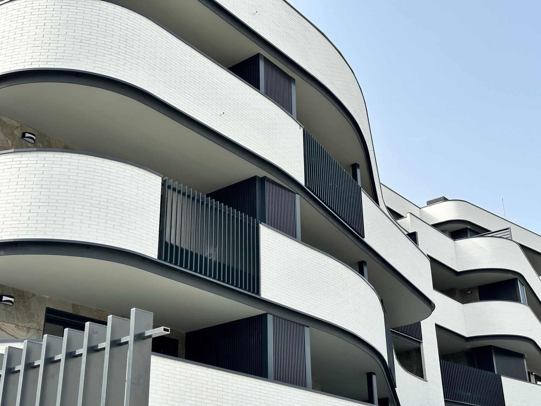 Celosías verticales integradas en balcones de geometría curva